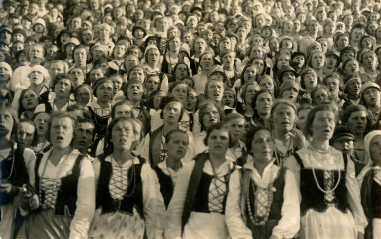 Senoje nuotraukoje dainuoja daug moterų ir merginų tautiniais drabužiais